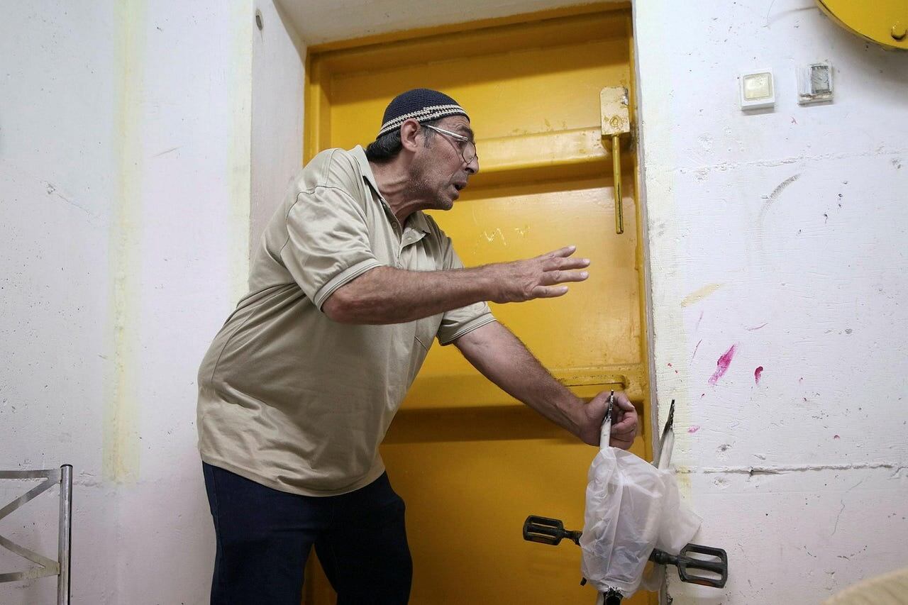 Ofakim resident Shuki Yosef demonstrates how he blocked a shelter door with the piece of a bicycle from terrorists.