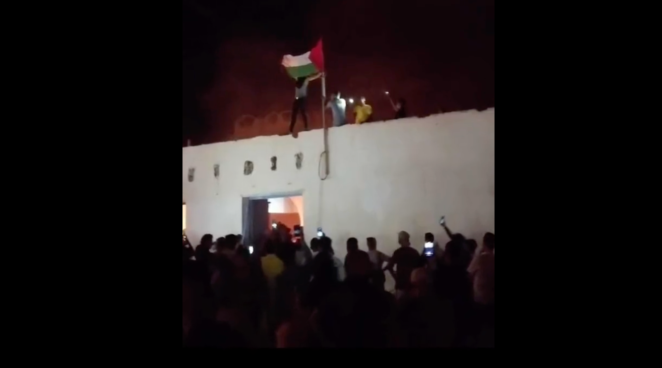 Tunisian protesters fly a Palestinian flag as a historic synagogue in Al Hammah burns, Oct. 17, 2023. (Screenshot via X)