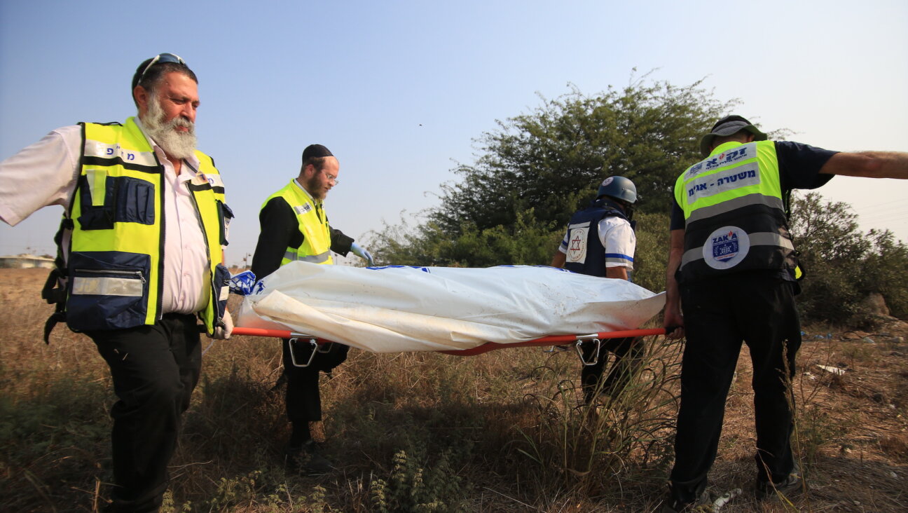 Medical responders carry a body bag in Sderot, Israel, Oct. 8, 2023. (Saeed Qaq/Anadolu Agency via Getty Images)