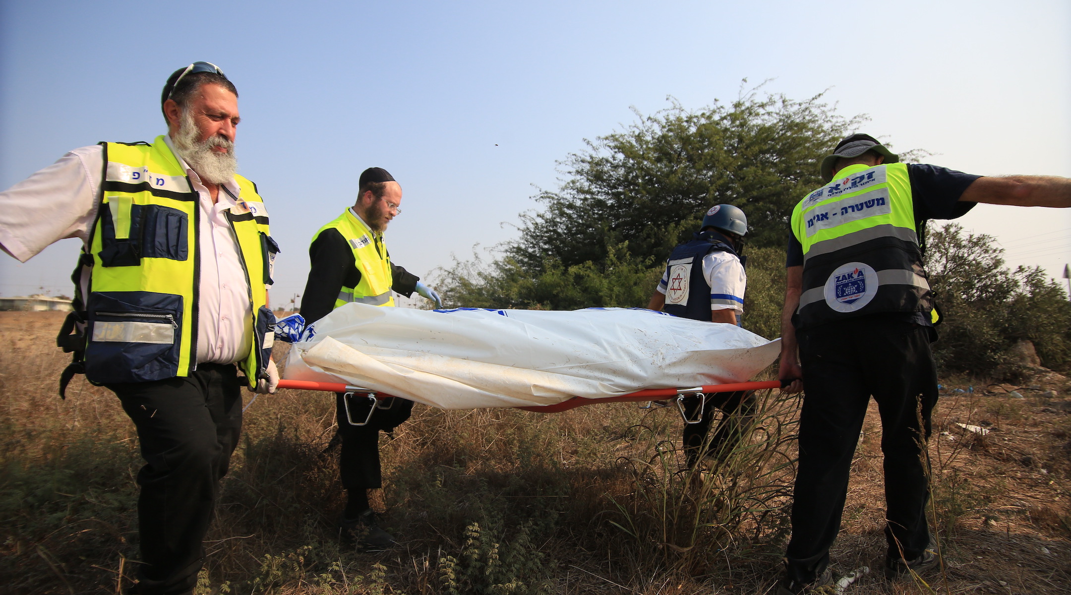 Medical responders carry a body bag in Sderot, Israel, Oct. 8, 2023. (Saeed Qaq/Anadolu Agency via Getty Images)