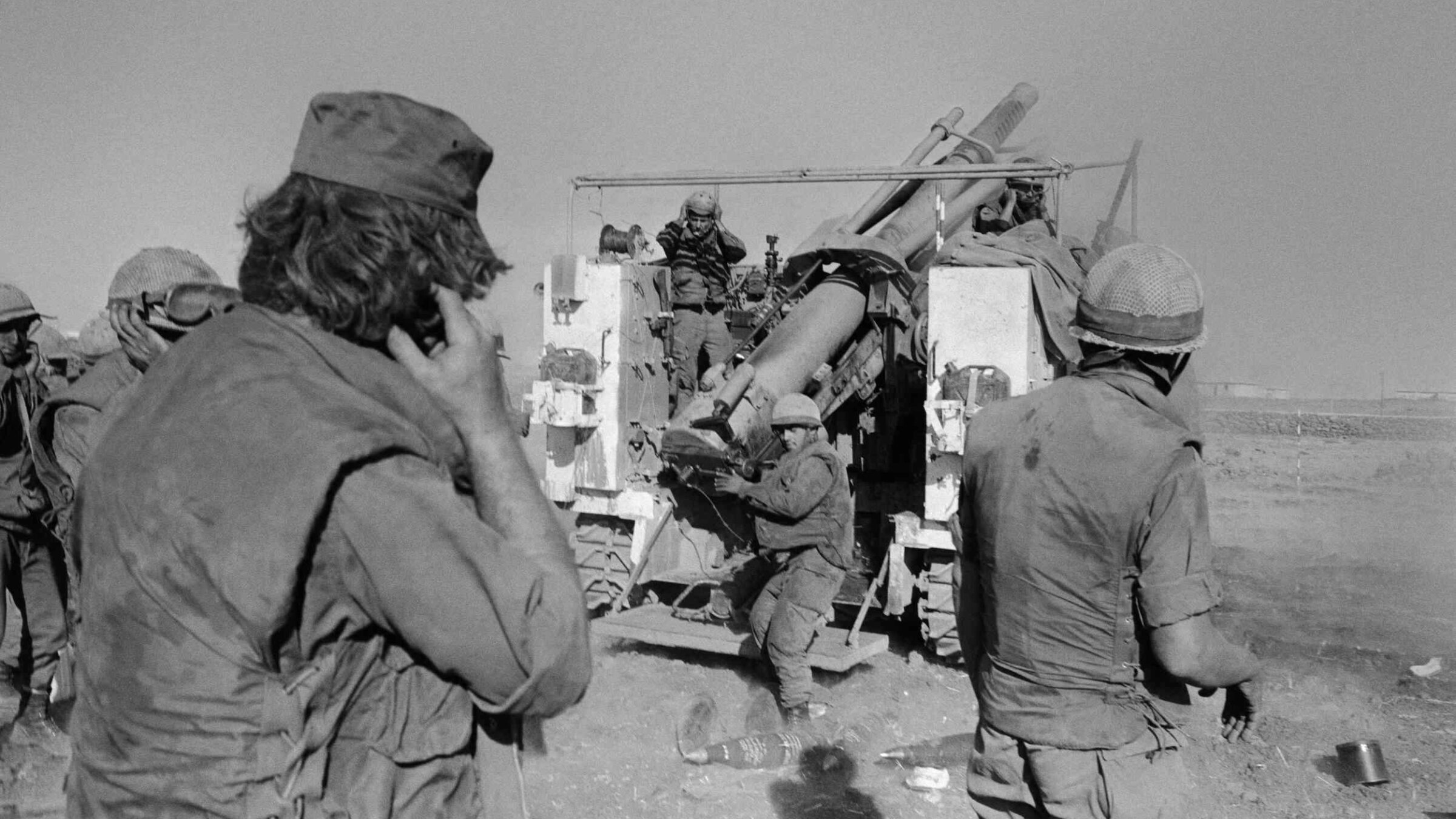 Israeli soldiers plug their ears as they fire shells at the Syrian lines on the Syrian Golan Heights, almost two weeks after the beginning of the Yom Kippur War, on Oct. 17, 1973. 