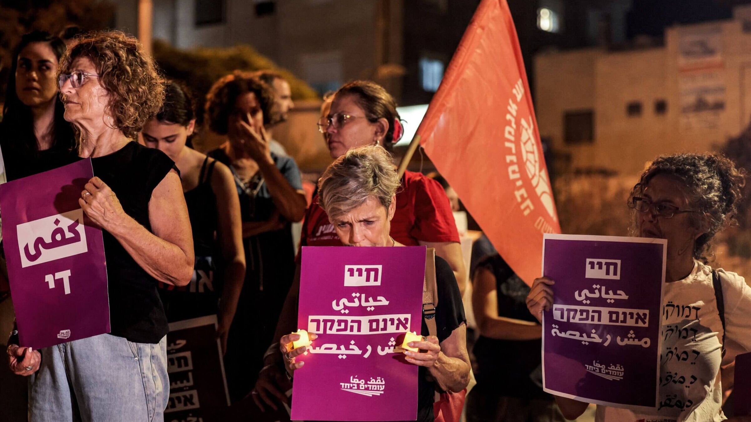 Members of Standing Together, an Israeli nonprofit that mobilizes Jewish and Palestinian Israelis for progressive causes, carry signs at a protest to bring Israeli hostages home. 