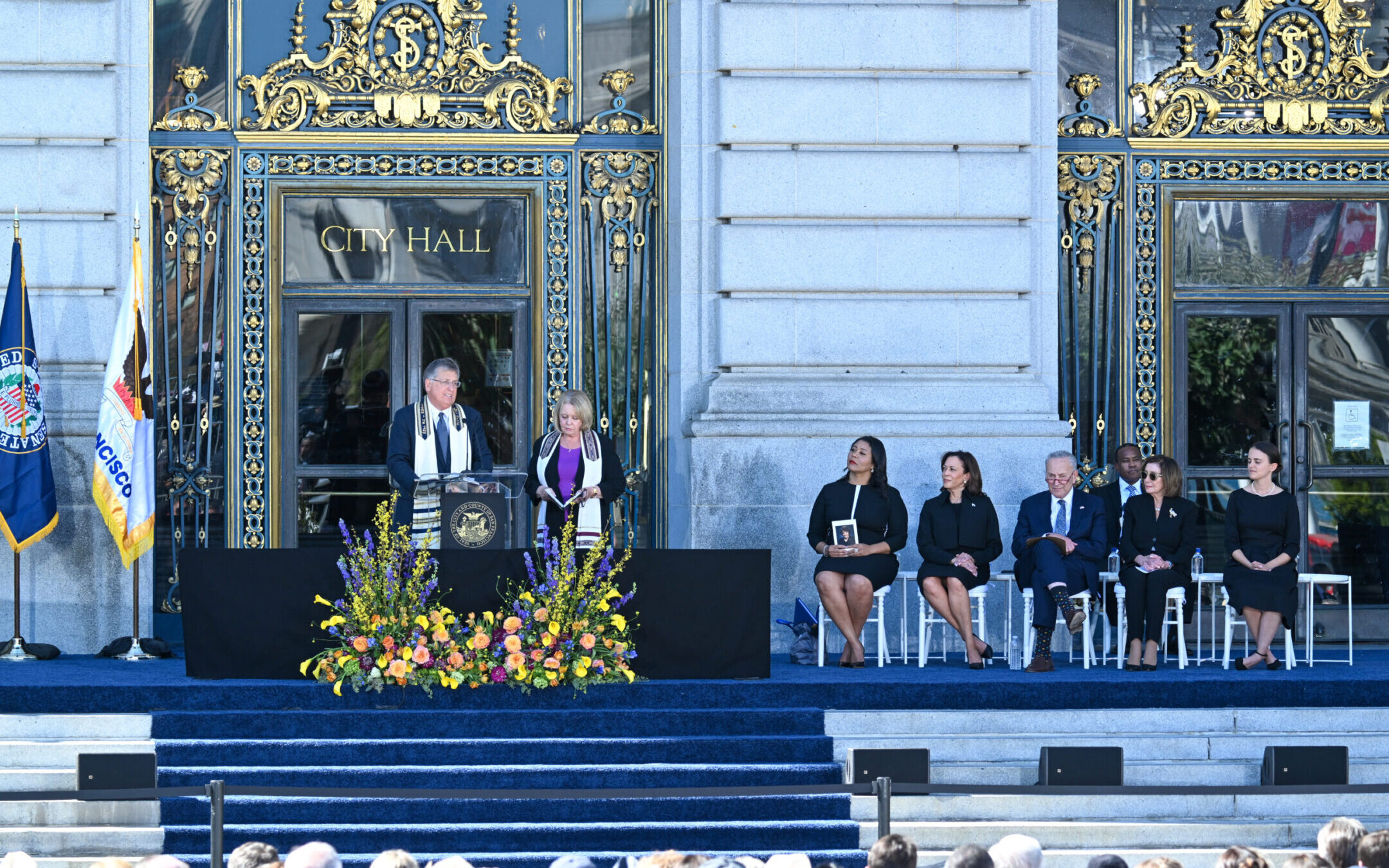 Rabbi Jonathan Singer speaks and Cantor Roz Barak stands beside him as (L-R) San Francisco Mayor London Breed, U.S Vice President Kamala Harris, Sen. Chuck Schumer, Rep. Nancy Pelosi and Dianne Feinstein’s granddaughter Eileen Feinstein Mariano attend a memorial service for Sen. Dianne Feinstein’s outside of San Francisco City Hall, Oct. 5, 2023. (Tayfun Coskun/Anadolu Agency via Getty Images)