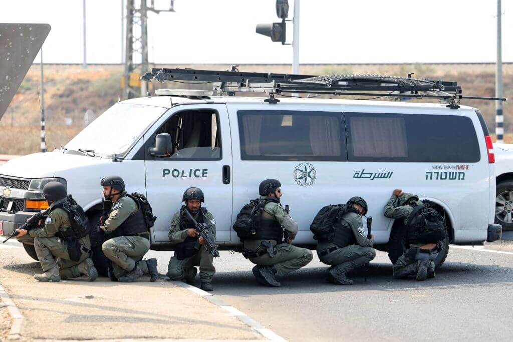 Israeli security forces take cover during a rocket attack near the southern city of Sderot on October 8, 2023.