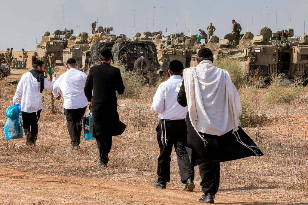 Haredi men visit Israeli soldiers on Oct. 11, 2023, near the border with Gaza. (Getty)