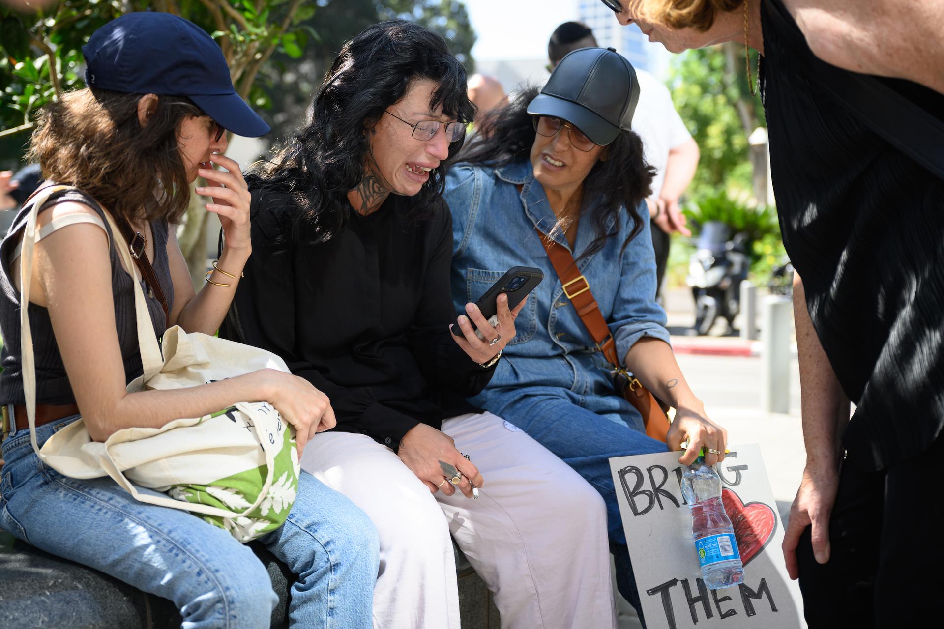 TEL AVIV: Friends comfort Osa Me'ir (center) Friday after she learned that the second of her twin brothers was confirmed killed during the Hamas attack. (Leon Neal/Getty Images)