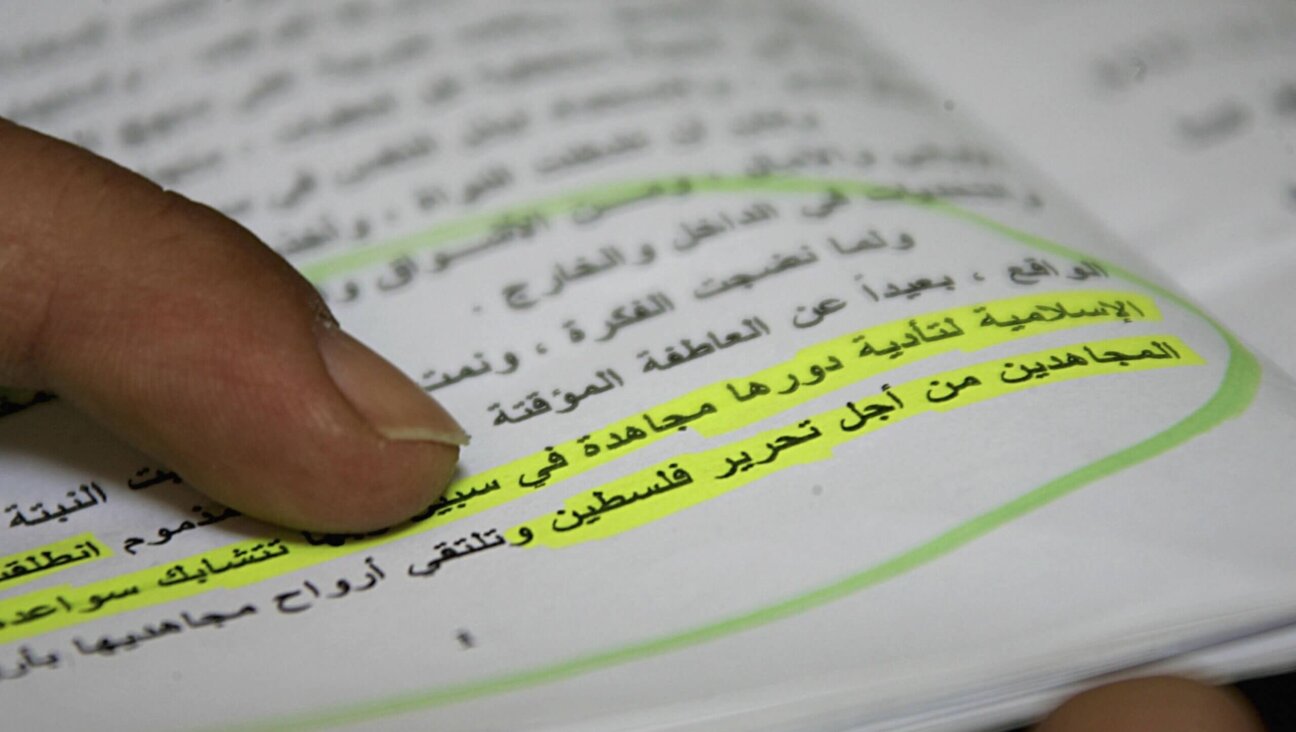 A Palestinian member of Hamas holds an Arabic copy of its charter in 2006. The highlighted sentence reads "When our enemies usurp some Islamic lands, Jihad becomes a duty binding on all Muslims. In order to face the usurping of Palestine by the Jews, we have no escape from raising the banner of Jihad." 