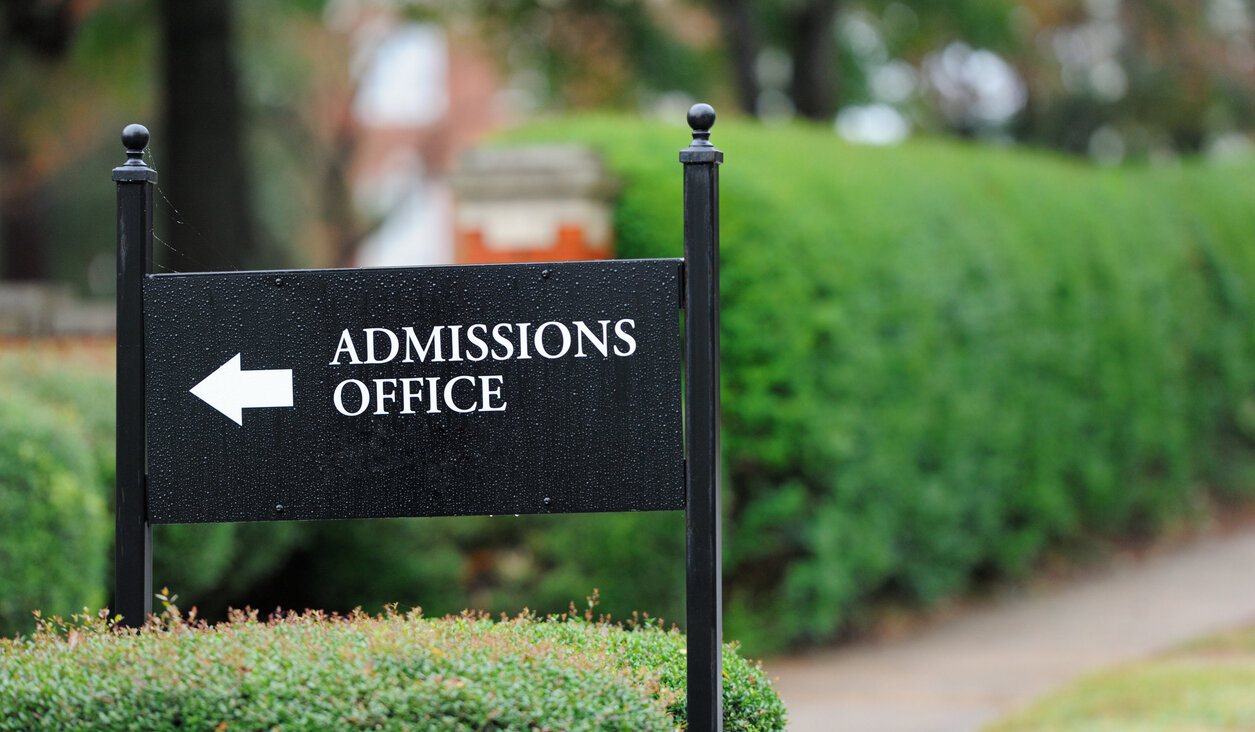 Close up of admissions office sign near public university campus.