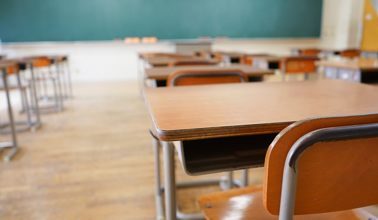 A classroom with an empty school desk.