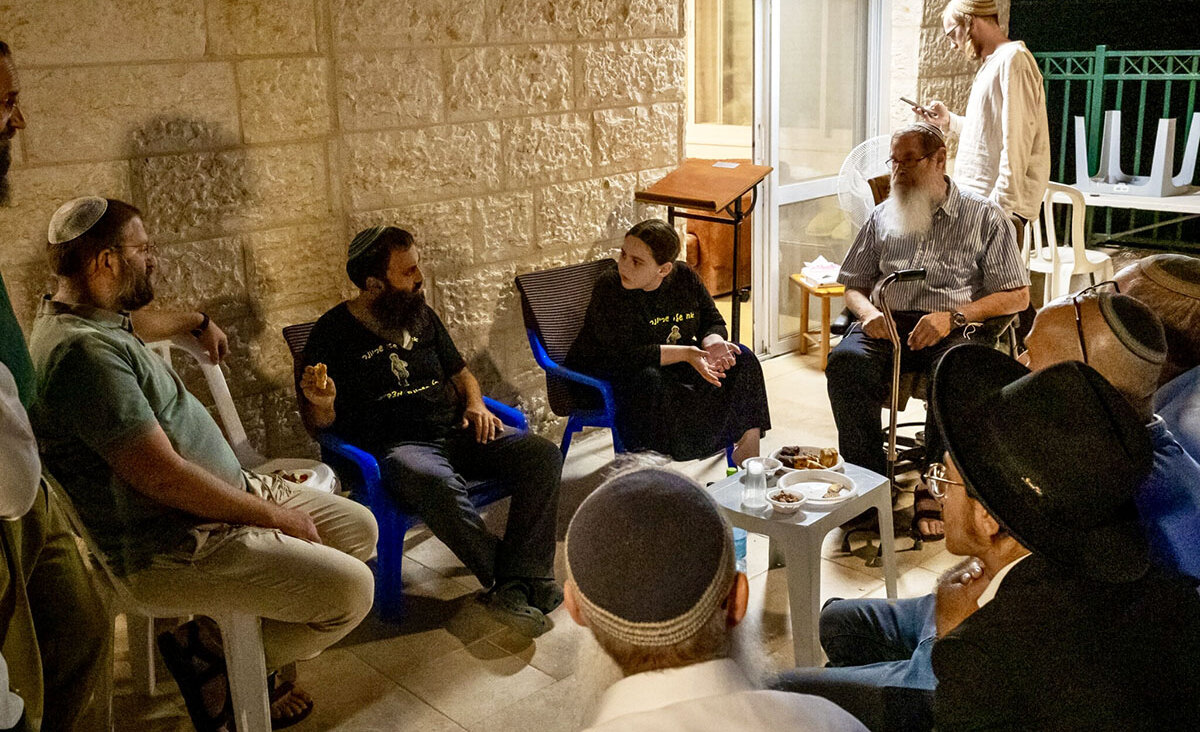 Residents of Mitzpe Yericho gather in the home of Rabbi Achiya Eliyahu (seated, in the black T-shirt) and Idit Eliyahu, who are sitting shiva following the death of their 19 year-old son, Ariel. (Laura Ben-David)