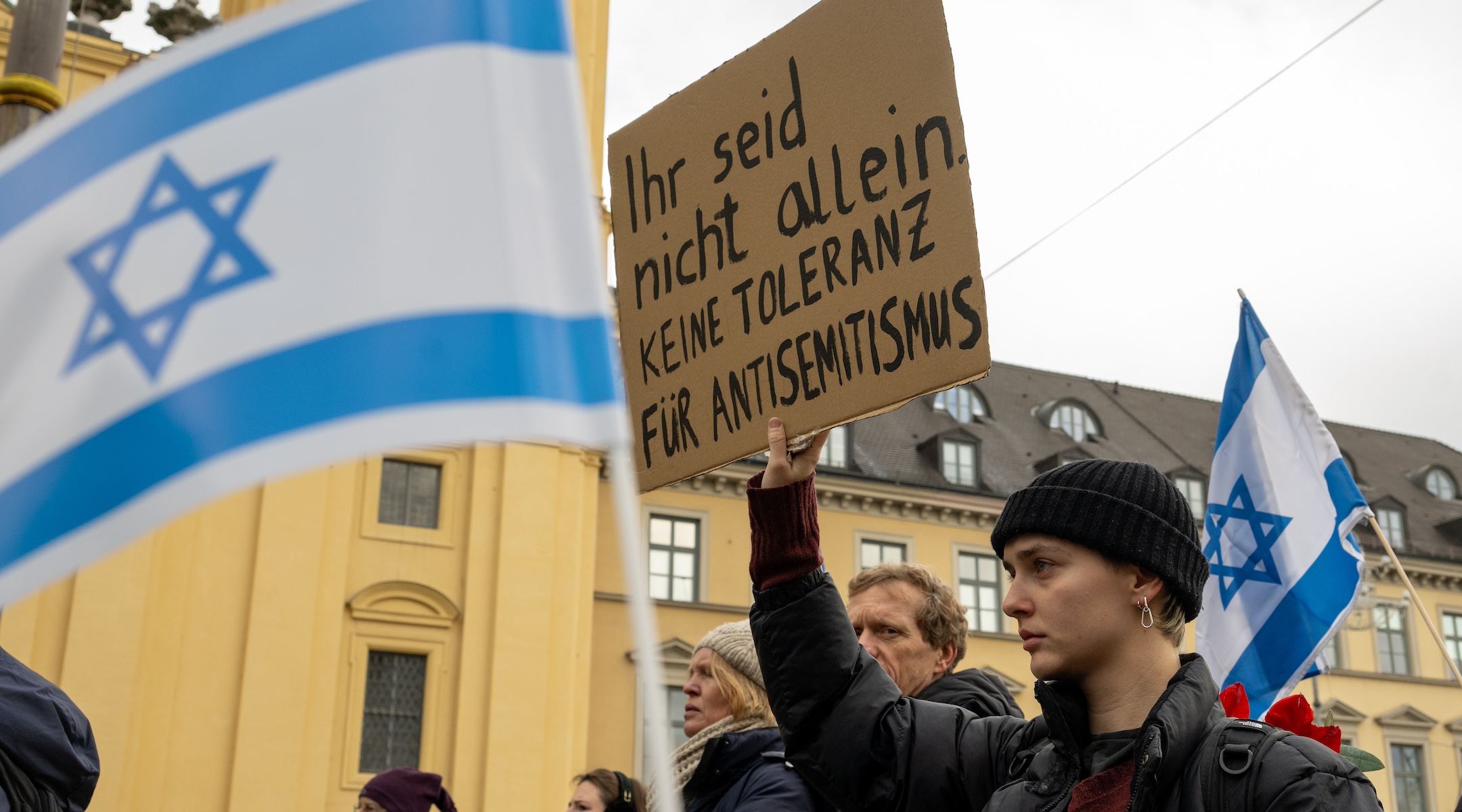 At a rally for Israel in Munich, a participant holds a sign reading “You are not alone. No tolerance for antisemitism,” Nov. 26, 2023. (Stefan Puchner/picture alliance via Getty Images)