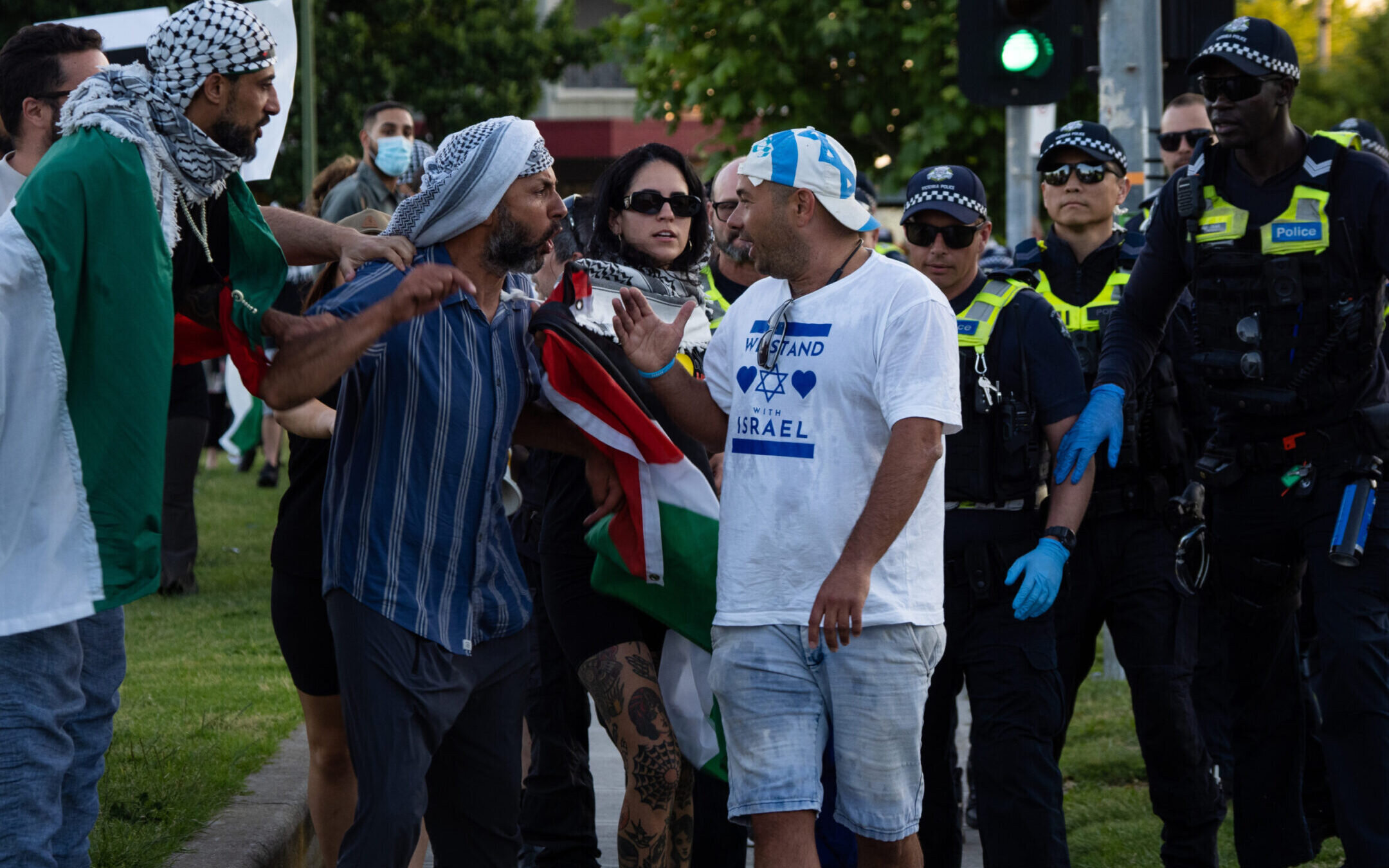 PRINCES PARK, CAUFIELD, VICTORIA, AUSTRALIA – 2023/11/10: Tense exchanges happen as a pro-Israel protester walks past the pro-Palestine demonstration. After a Burgertory chain-restaurant owned by Palestinian-Australian Hesham Tayah burned overnight in Melbourne’s most-Jewish suburb, Pro-Palestine protesters gathered in a nearby park where violent exchanges occurred with pro-Israel counter-protesters. Police deployed pepper spray on both sides and made one arrest. (Photo by Alex Zucco/SOPA Images/LightRocket via Getty Images)