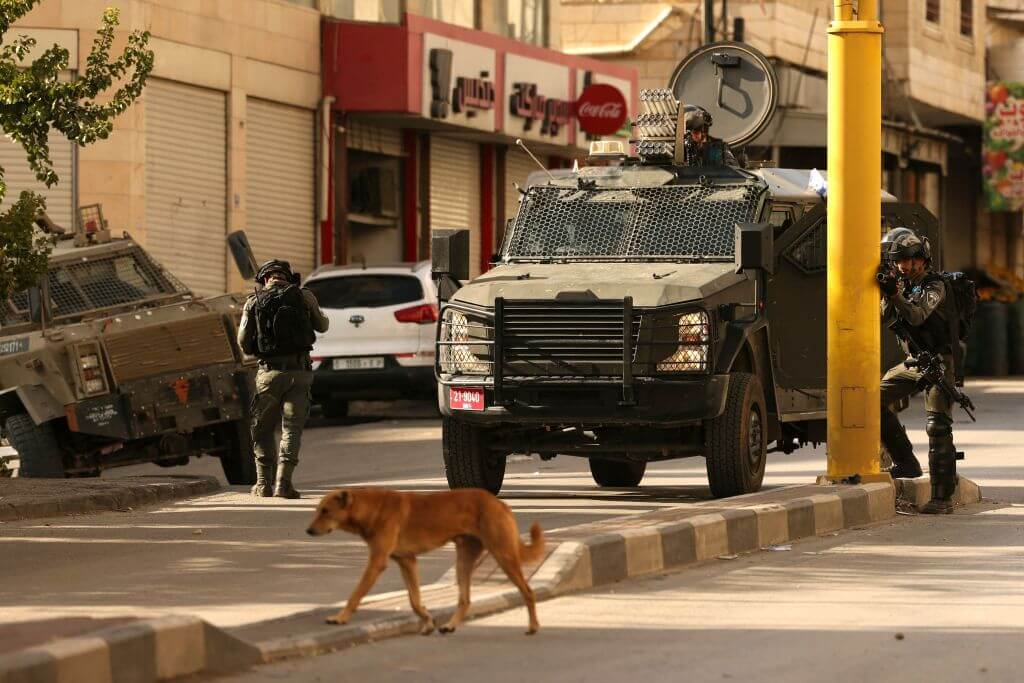 Israeli security forces surround the area of a Palestinian home, believed to belong to one of the gunmen that attacked an Israel checkpoint on the edge of Jerusalem earlier in the day, during a military operation in the occupied West Bank city of Hebron on November 16, 2023, amid the ongoing battles between Israel and the Palestinian group Hamas.