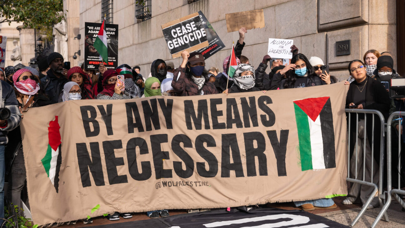 Students participate in a protest in support of Palestine outside of the Columbia University campus on Nov. 15. A large banner reads, "by any means necessary," with an image of the Palestinian flag