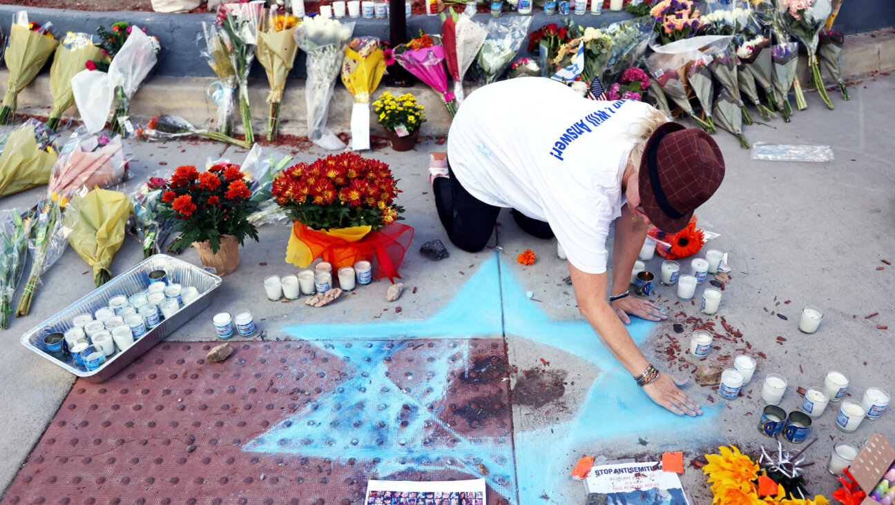 Elena Colombo draws a Star of David at a makeshift memorial to 69-year-old Paul Kessler, who died following a Sunday altercation with a pro-Palestinian protestor in Thousand Oaks, California.