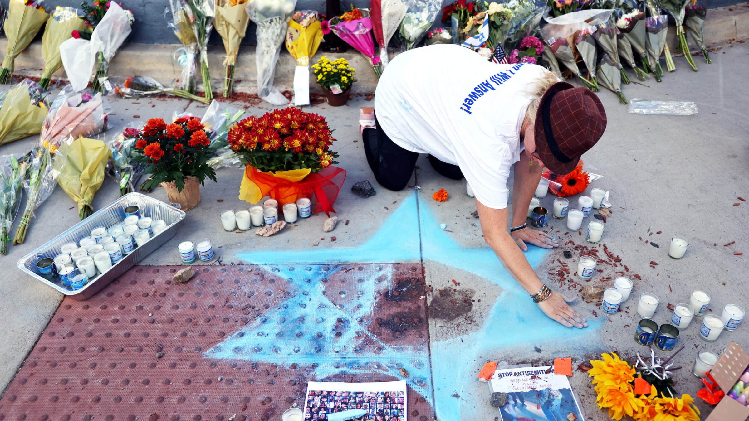 Elena Colombo draws a Star of David at a makeshift memorial to 69-year-old Paul Kessler, who died following a Sunday altercation with a pro-Palestinian protestor in Thousand Oaks, California.