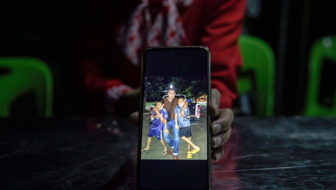 Kanyarat Suriyasri, the wife of Owat Suriyasri, a Thai worker who is being held hostage by Hamas in Gaza, shows a picture of him with their two children.