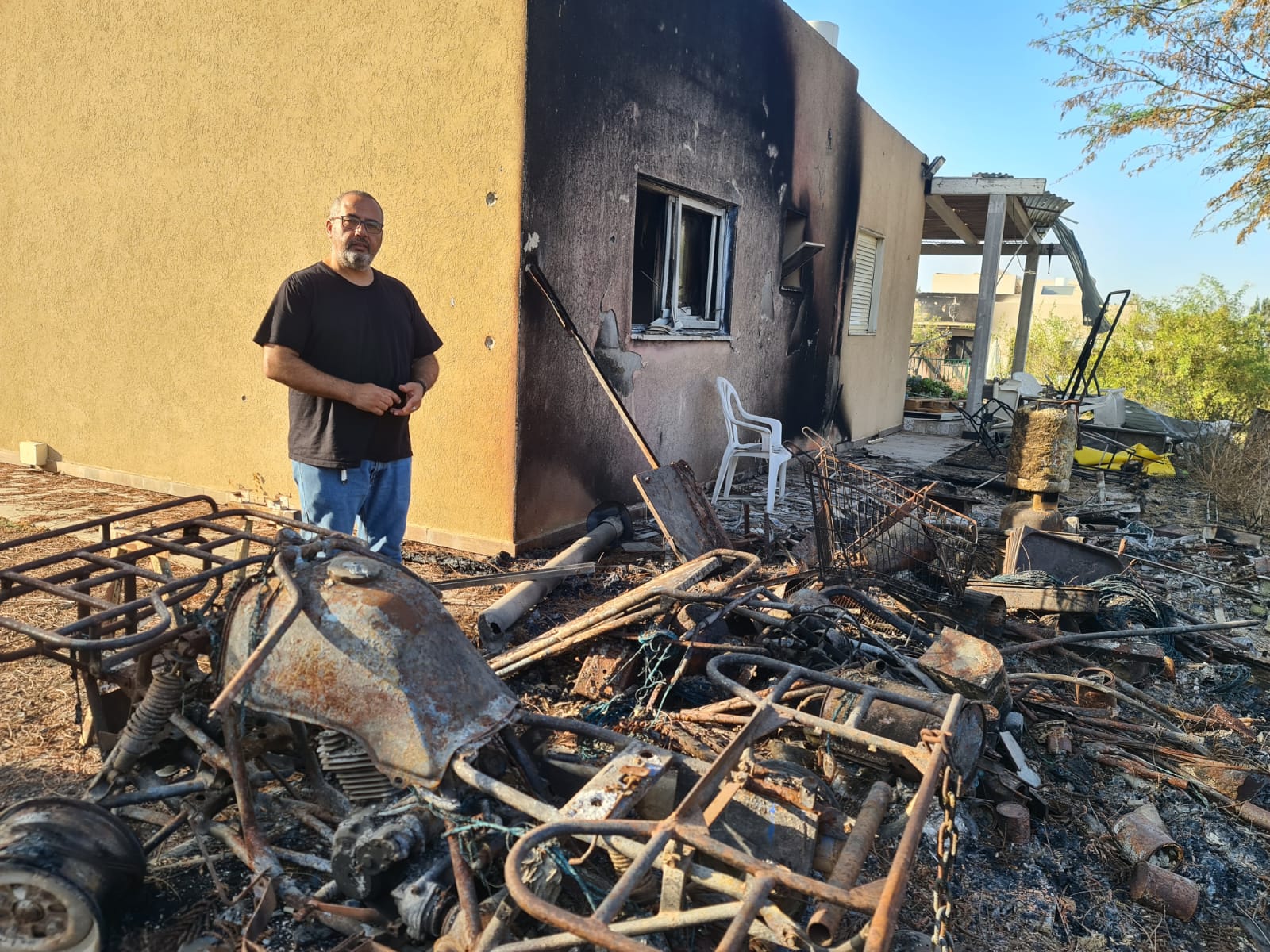 Gili Okev sits outside his ruined house in Kfar Aza, Israel, a month after Hamas terrorists invaded and killed many of his neighbors. He doesn’t know why he was spared. (Deborah Danan)