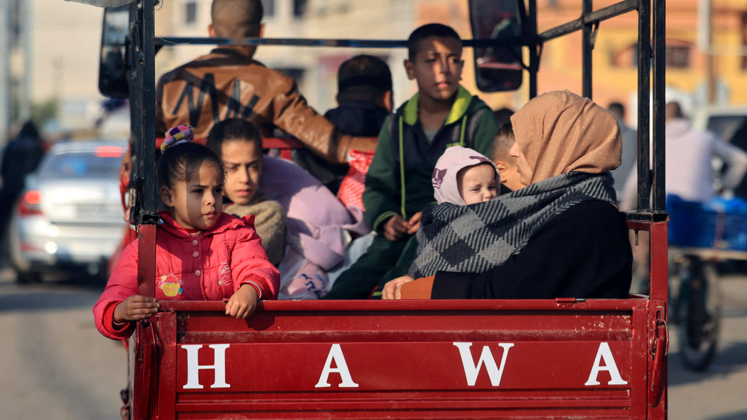 Palestinians ride in the back of a vehicle as they move toward safer areas following the resumption of Israeli strikes on Rafah in the southern Gaza Strip on Dec. 1. A large majority of Americans say Hamas bears "a lot" of responsibility for the current war, although they are more skeptical of how President Joe Biden has responded.