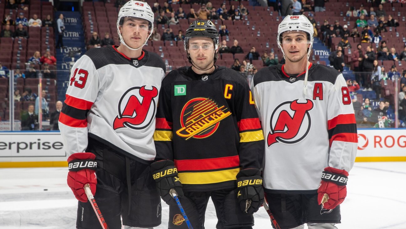 From left to right: Luke, Quinn and Jack Hughes pose for a photo before their NHL game at Rogers Arena in Vancouver, Dec. 5, 2023. (Jeff Vinnick/NHLI via Getty Images)