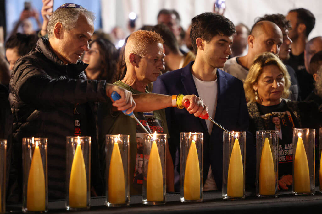 Families and supporters of Israeli hostages still held in the Gaza Strip since October 7 attend a lighting ceremony for a 138-branched menorah representing their number, on the eve of the first day of Hanukkah in Tel Aviv on December 7, 2023.