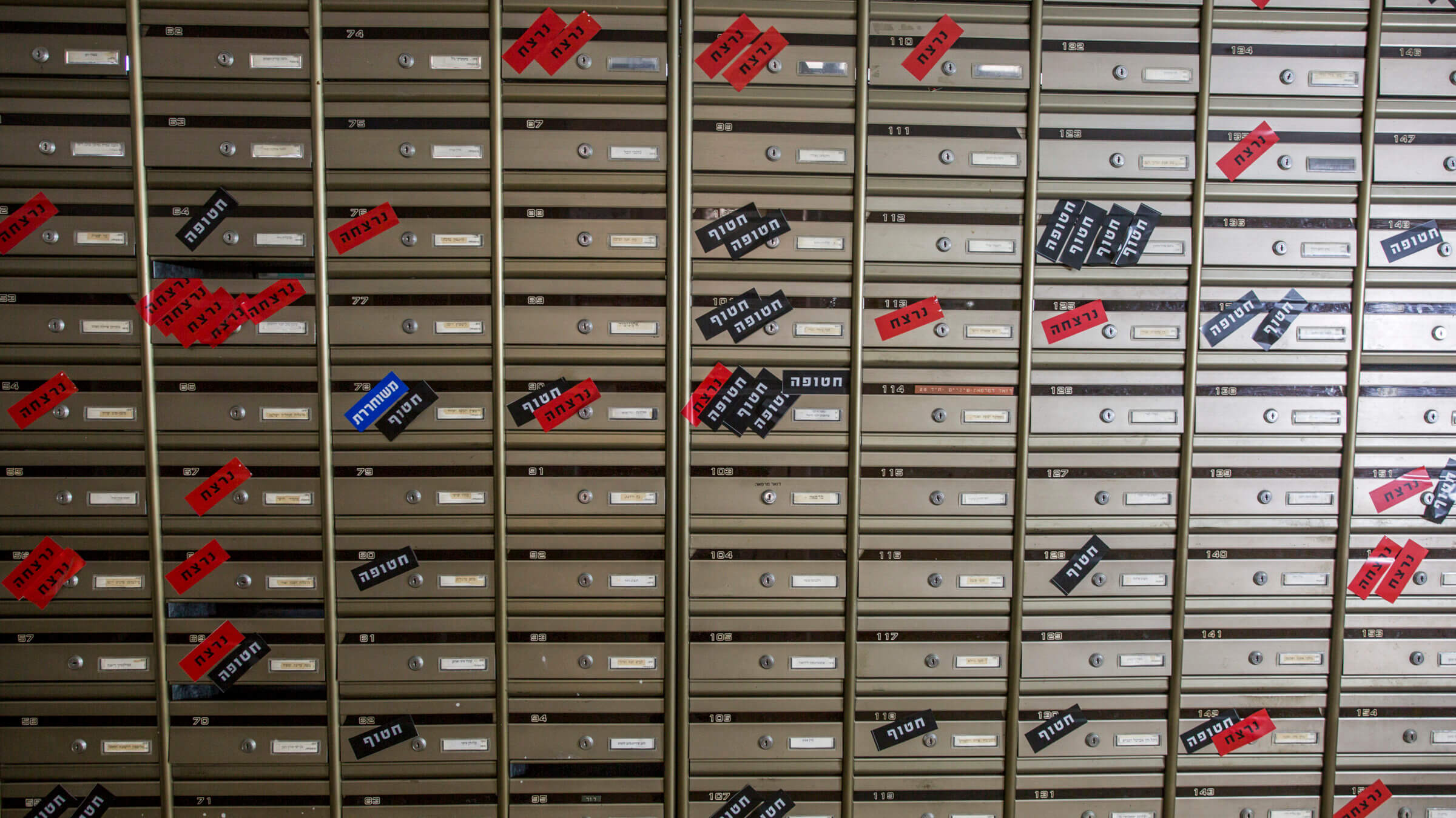 Survivors have placed stickers on residents’ mailboxes. The red ones say “murdered” in Hebrew. Black marks the 71 hostages taken. Blue signals the 40 who have been released.