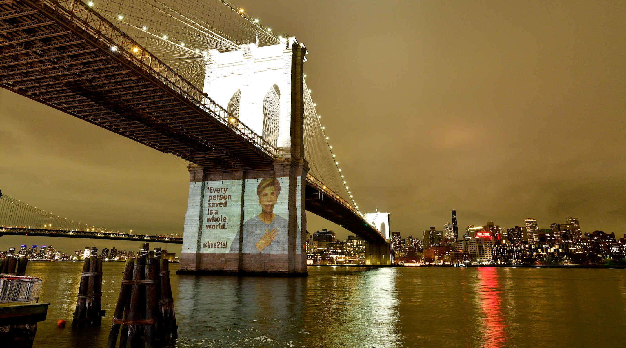 An image of Faye Tzippy Holand, an 83-year-old Holocaust survivor, projected on Brooklyn Bridge, Jan. 27, 2024, New York City. (Eugene Gologursky)