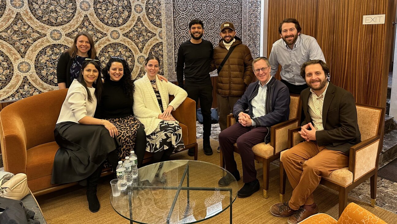 Members of a conversion program meeting in New York City on Dec. 21, 2023. Jasamine Hodge is seated in the center in a white sweater, with her fiancé Adir standing to her left. Seated on the right are Rabbis Adam Mintz and Avram Mlotek. (Courtesy of Hodge)