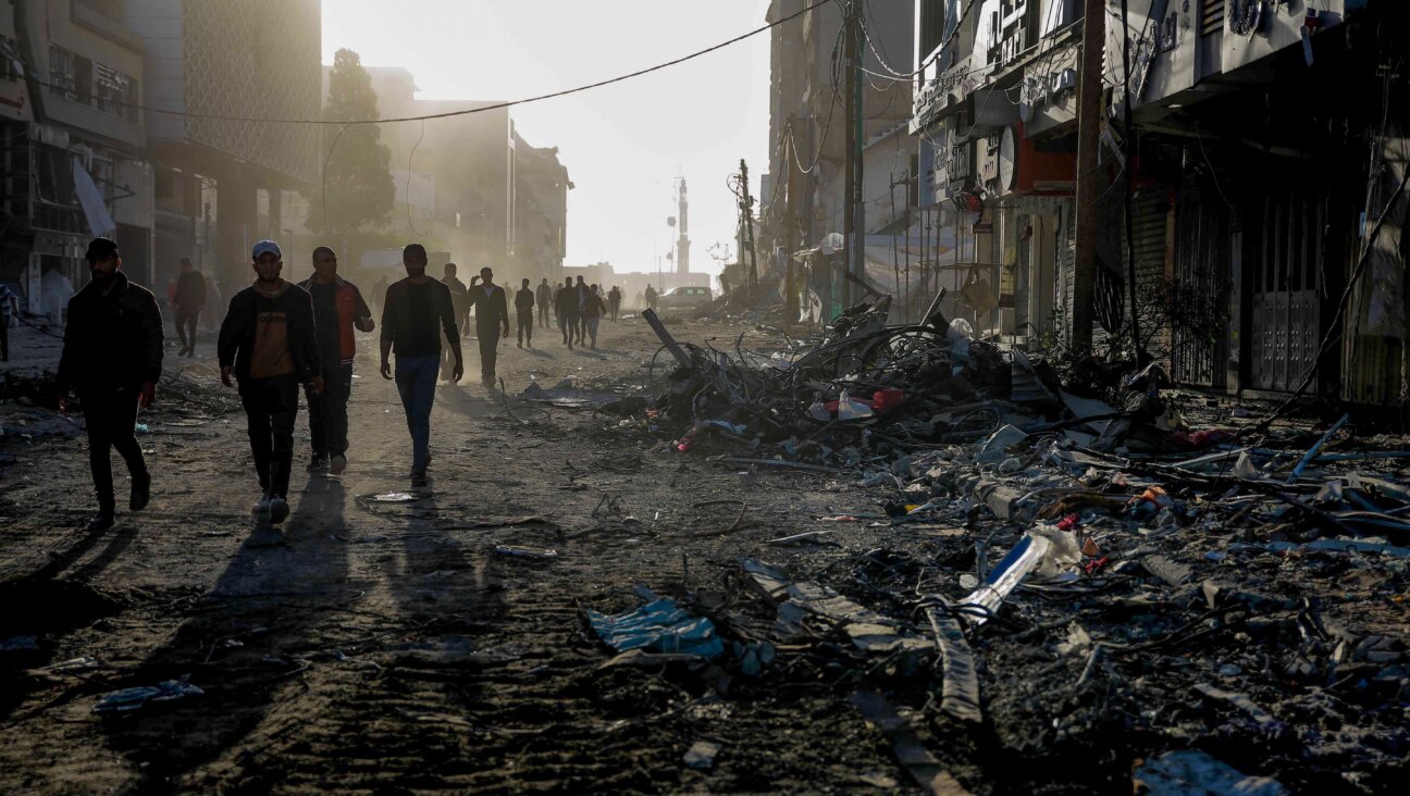 Palestinians walk amid the rubble of destroyed buildings in Gaza City on Nov. 24, 2023.