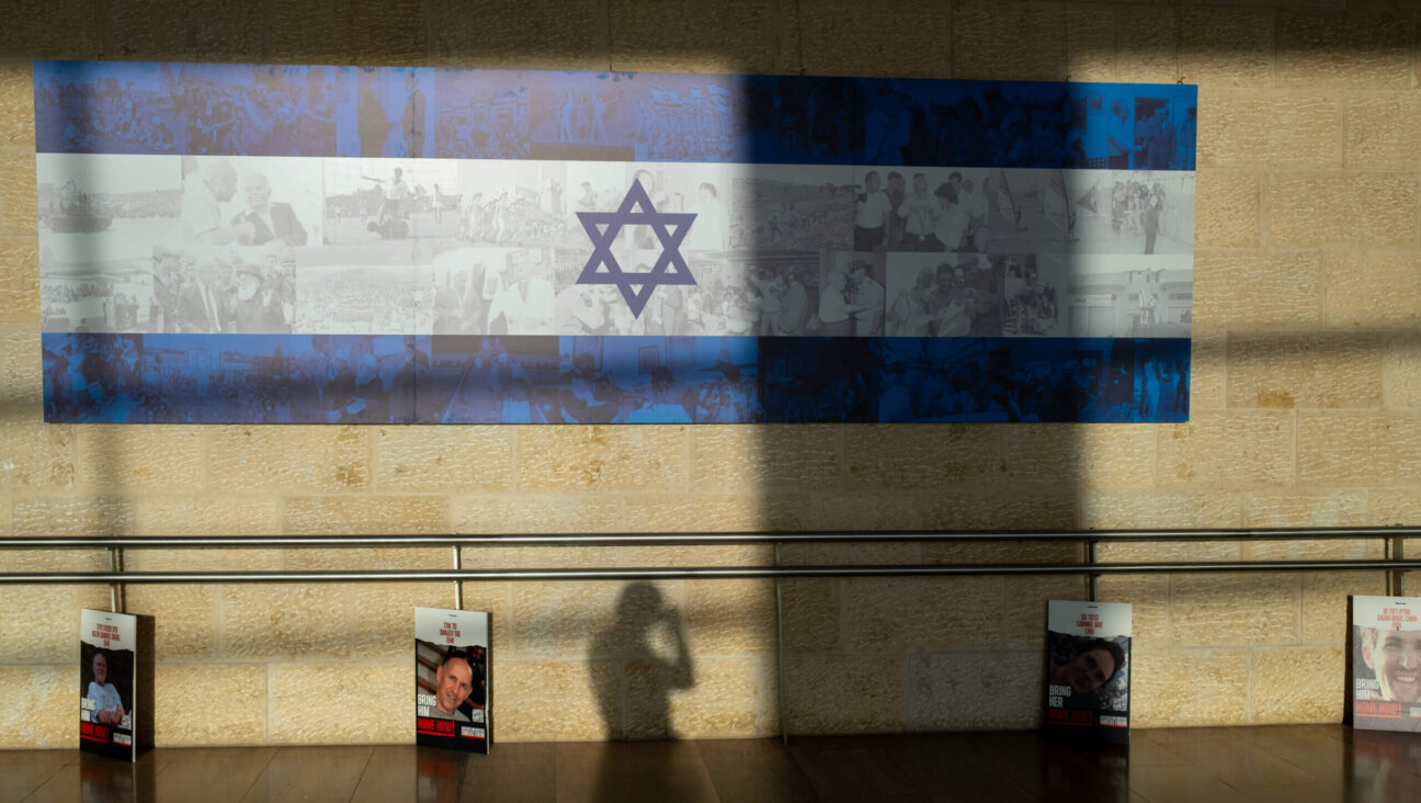 People walk past posters of hostages displayed before entering the departures hall in the Ben Gurion Airport on Dec. 25, 2023.