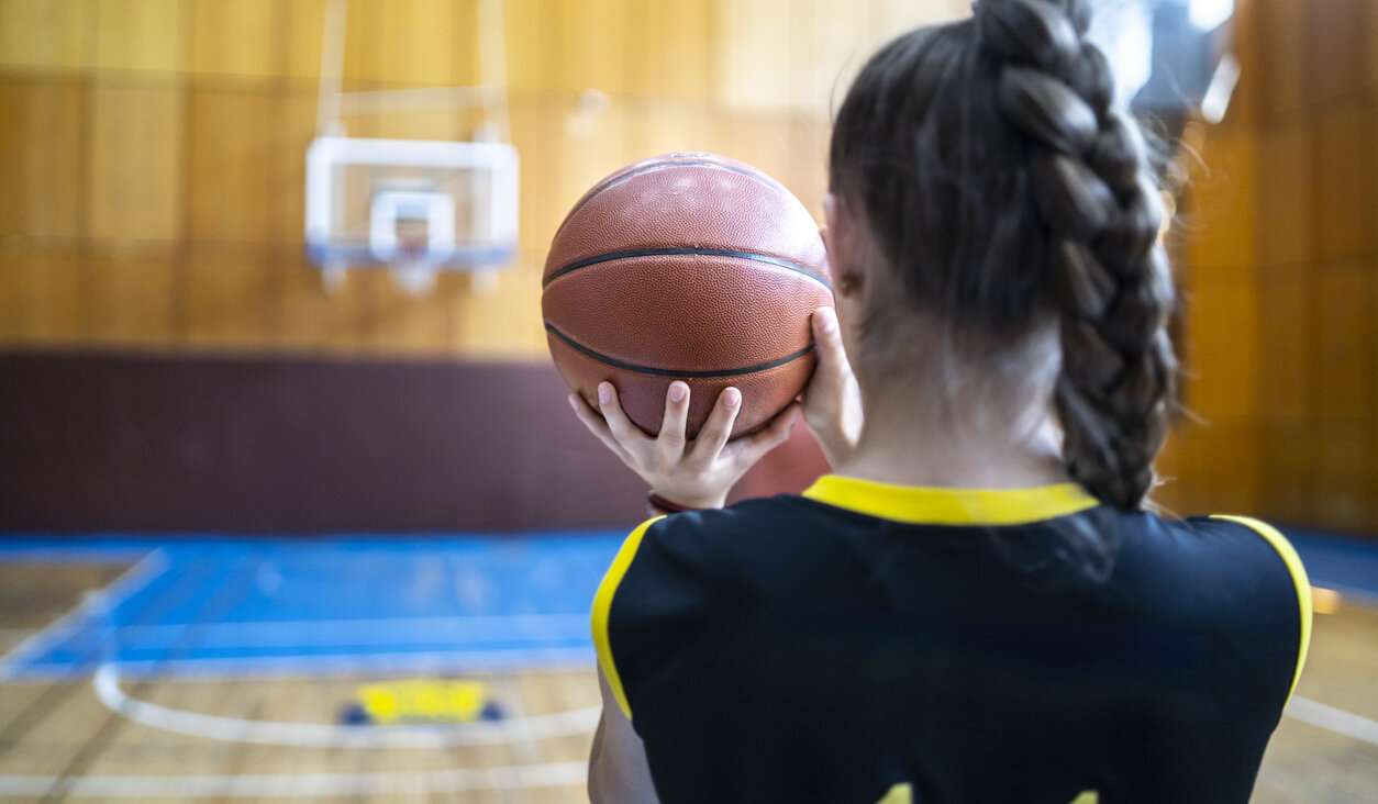 A basketball player takes aim.