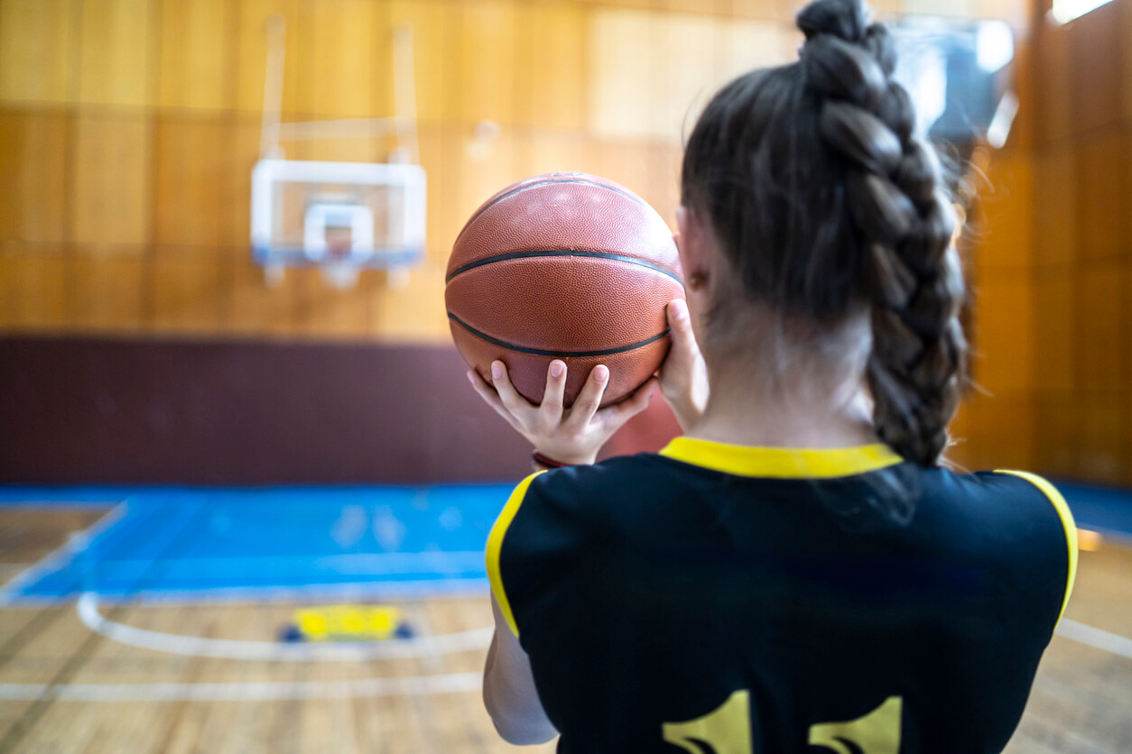 A basketball player takes aim.