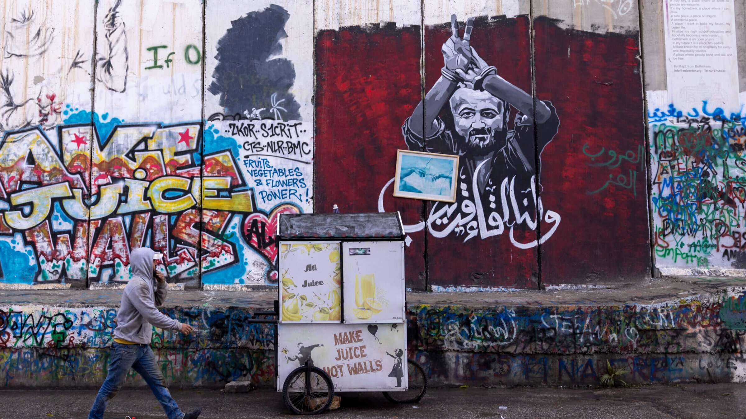 A Palestinian man pass the graffiti showing Marwan Barghouti, a Palestinian imprisoned politician on December 24, 2023 in Bethlehem, West Bank. Last month, Christian Palestinian leaders here called off public Christmas celebrations, citing the effects of the ongoing war in Gaza. 