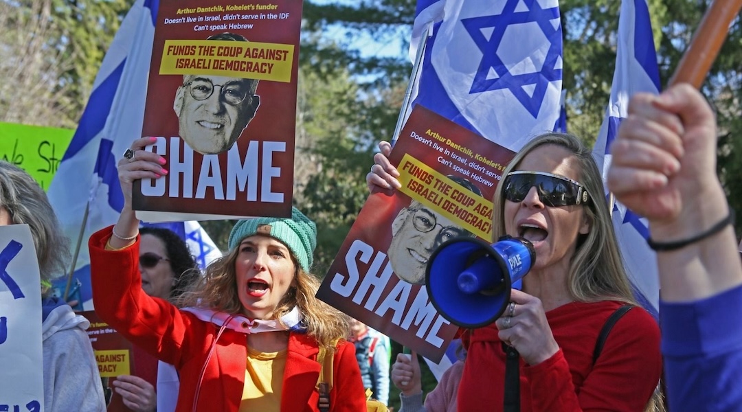 Protesters demonstrating against the Kohelet Policy Forum carry placards criticizing Arthur Dantchik near his home in suburban Philadelphia, March 26, 2023. (Roy Boshi)