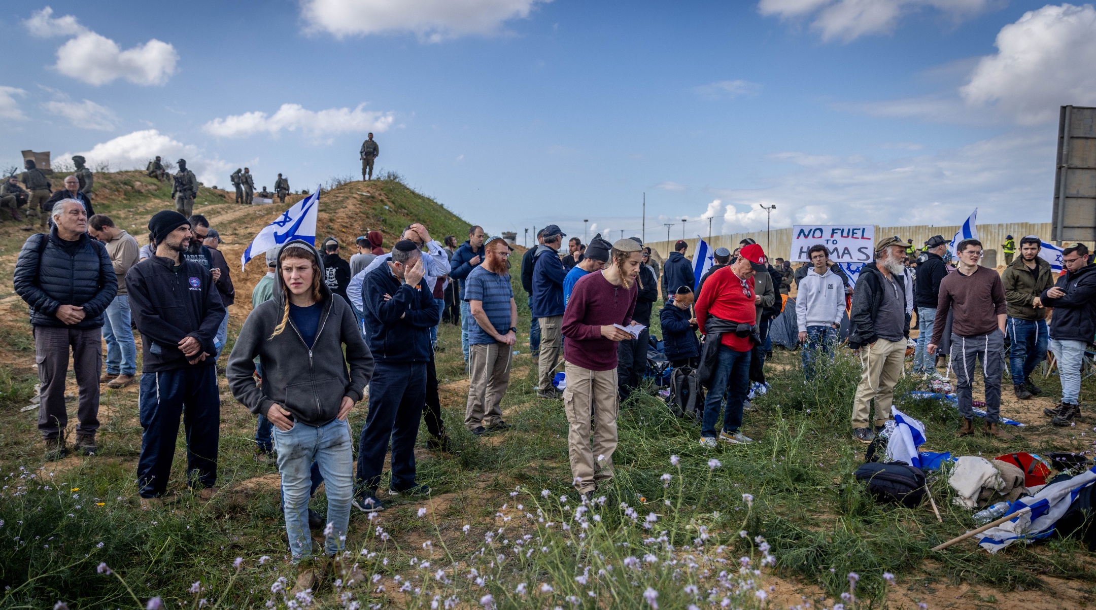 Israeli security forces guard while people protest against aid trucks entering the Gaza Strip, at the Kerem Shalom crossing in southern Israel, Jan. 29, 2024. (Chaim Goldberg/Flash90)