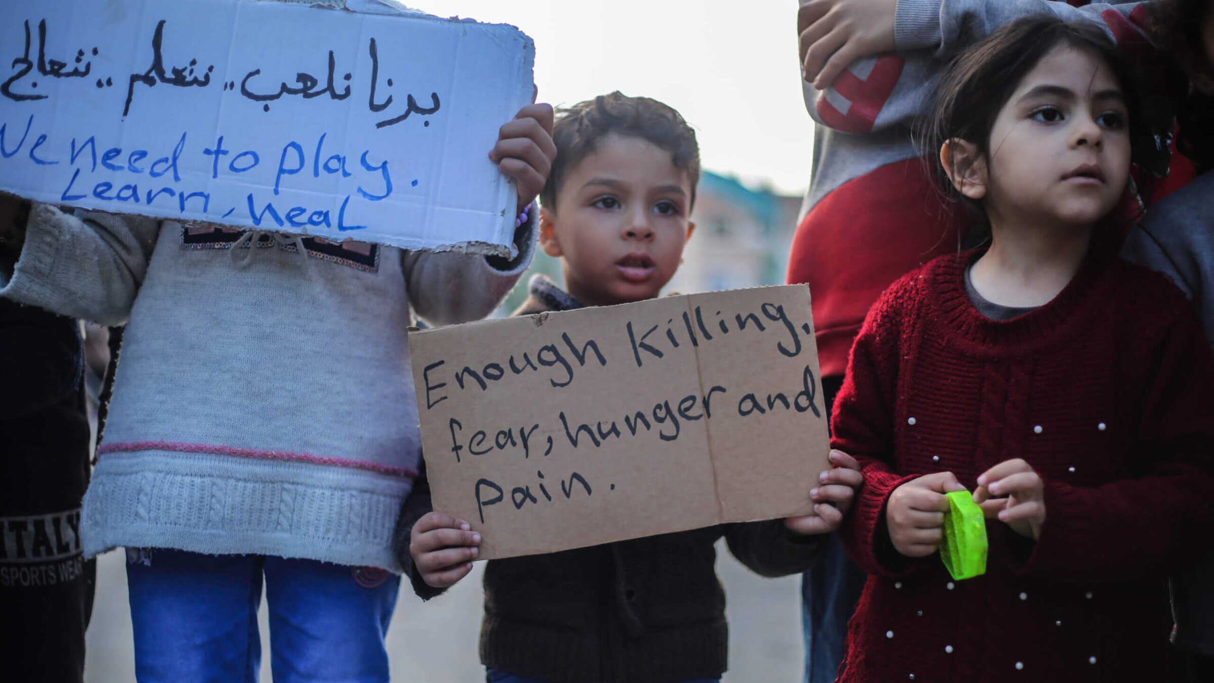 Palestinian children hold placards during a march demanding an end to the war, Feb. 14, in Rafah, Gaza. 