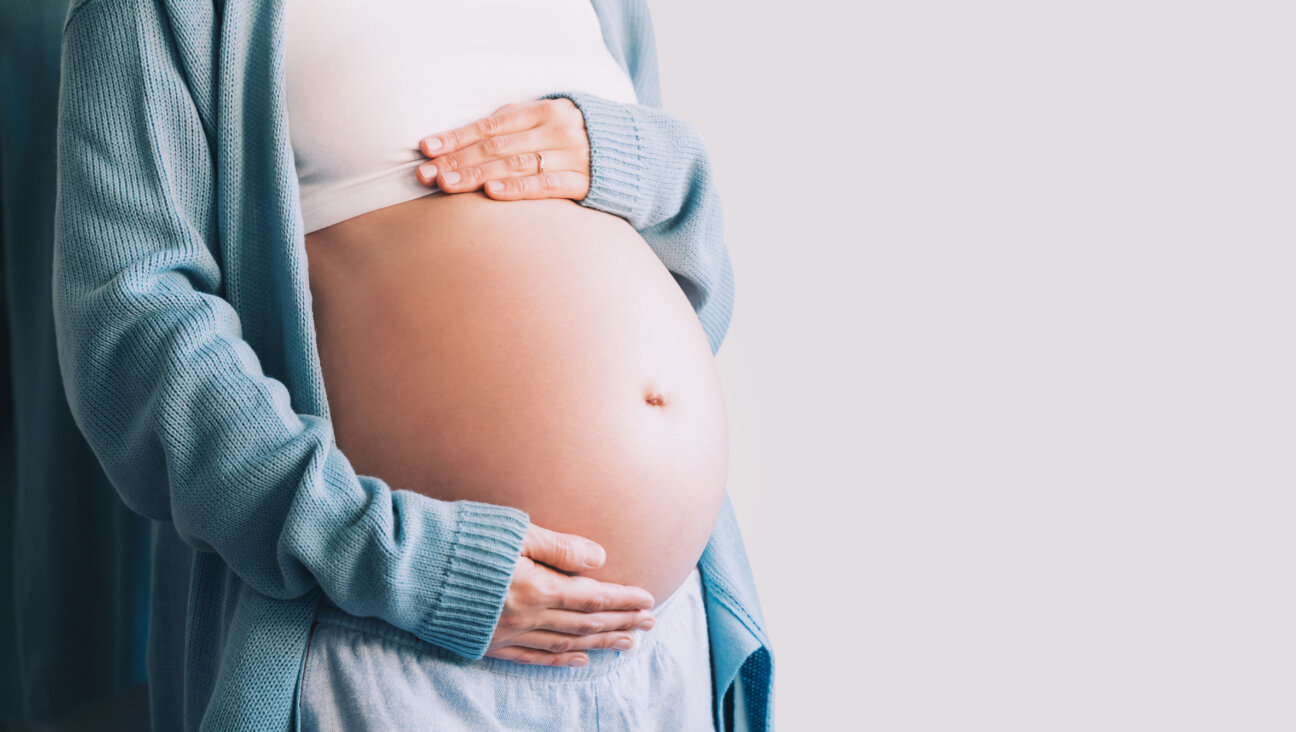 A pregnant woman holds her belly.