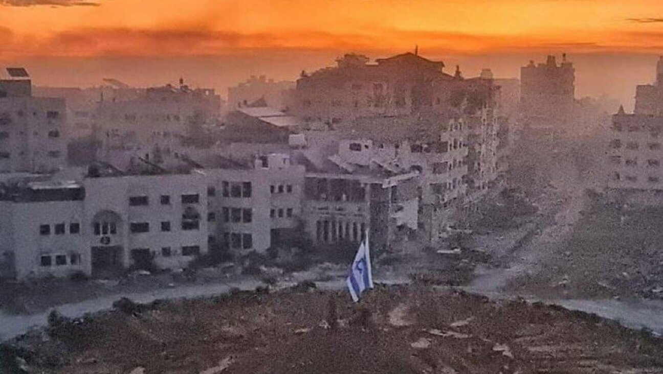 An Israeli flag is planted amid a central square in the ruins of Gaza City.