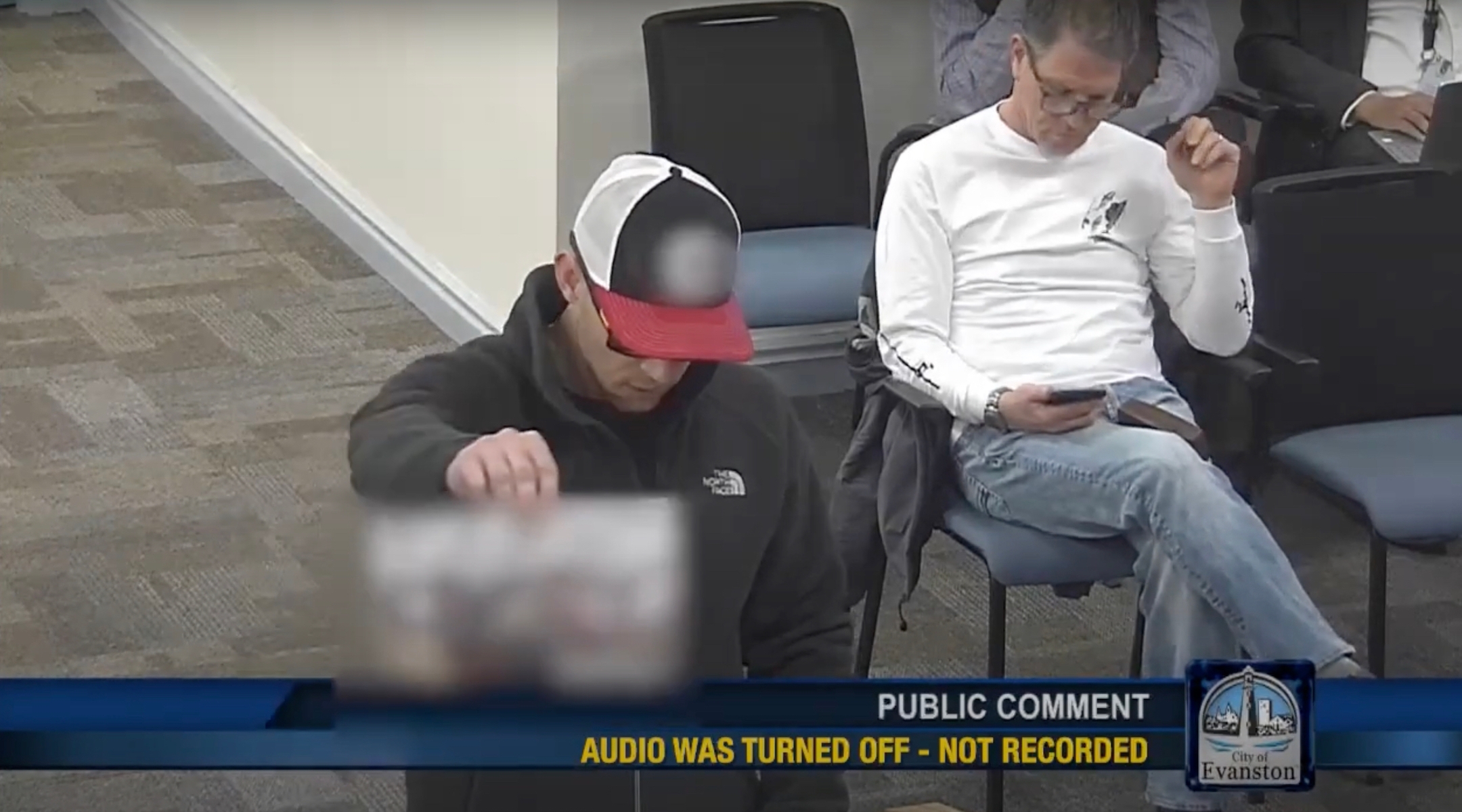 A neo-Nazi speaker is blurred out and his microphone is cut off as he speaks during a city council meeting in Evanston, Illinois, Feb. 22, 2024. (Screenshot via YouTube)