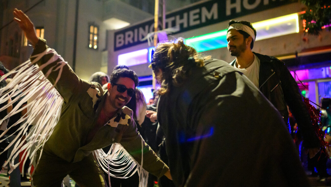 Eyal Lasry, 32, dressed as a cowboy/IDF soldier dances during Purim celebrations into the early hours of the morning near a large “Bring Them Home Now” banner on March 24, 2024 in Tel Aviv. (Alexi J. Rosenfeld/Getty Images)