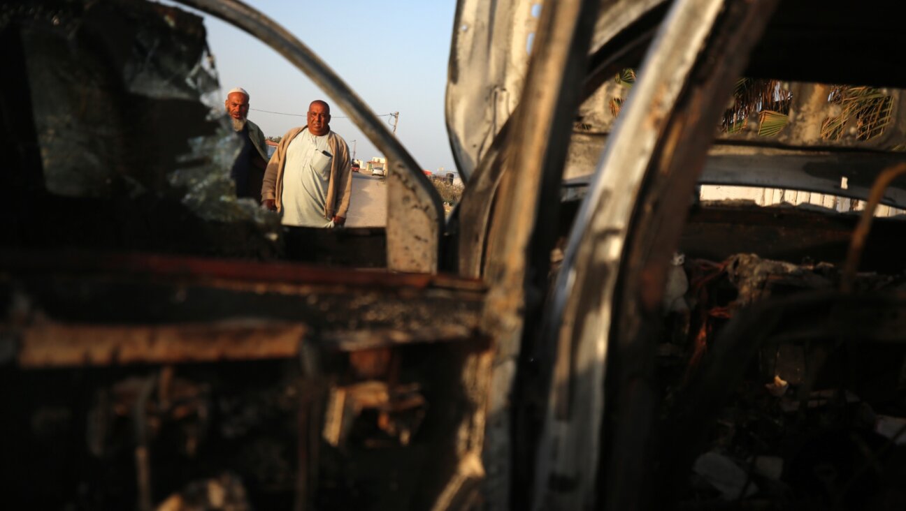 Palestinians stand next to a vehicle, where volunteers from the World Central Kitchen, including foreigners, were killed in an Israeli airstrike, according to the NGO, in Deir Al-Balah, in the central Gaza Strip, April 2, 2024. (Majdi Fathi/NurPhoto/Getty Images)