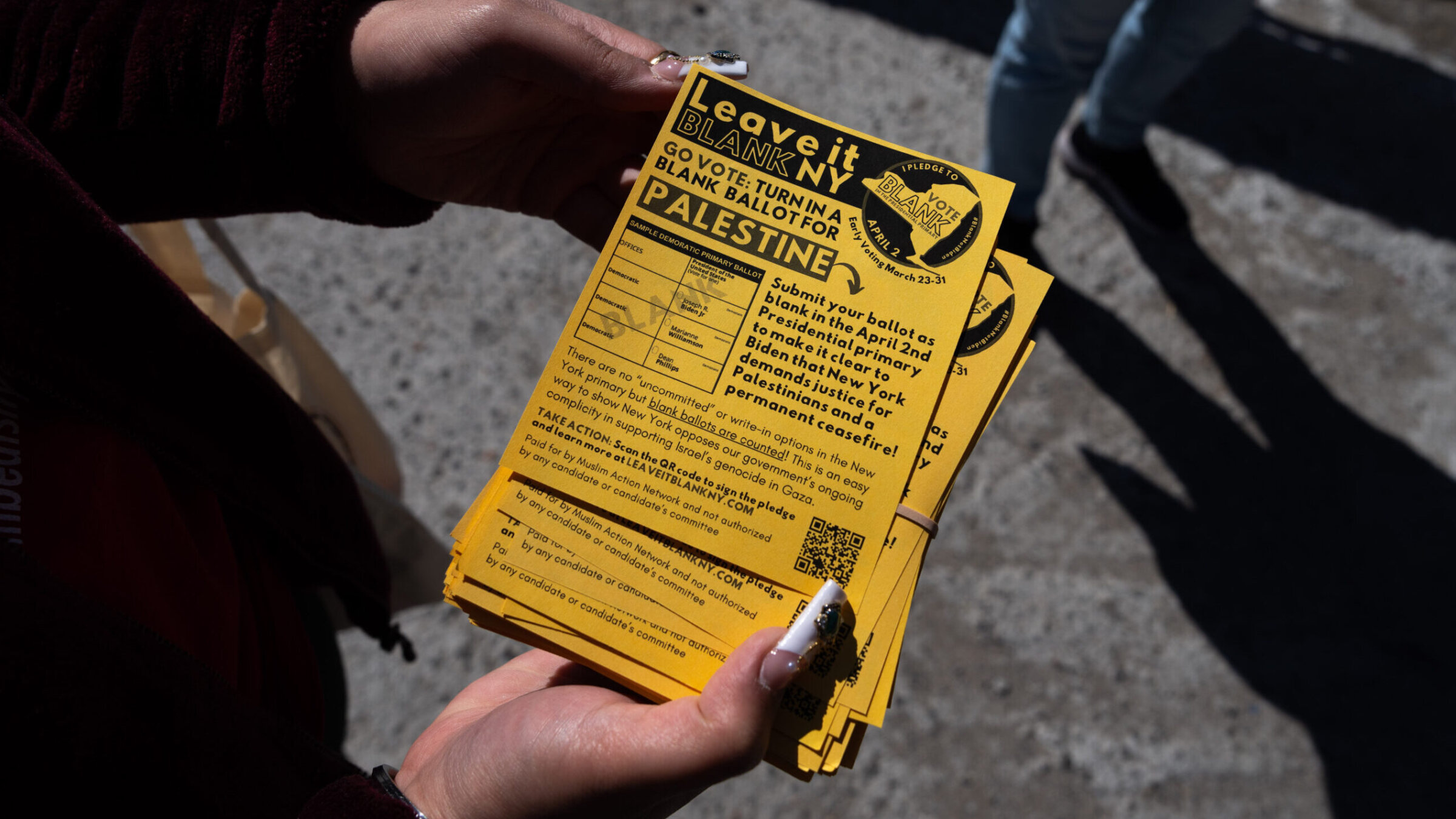 A campaigner in Queens holds a Leave it Blank flyer ahead of New York’s presidential primary, March 29, 2024. (Adam Gray/Getty Images)