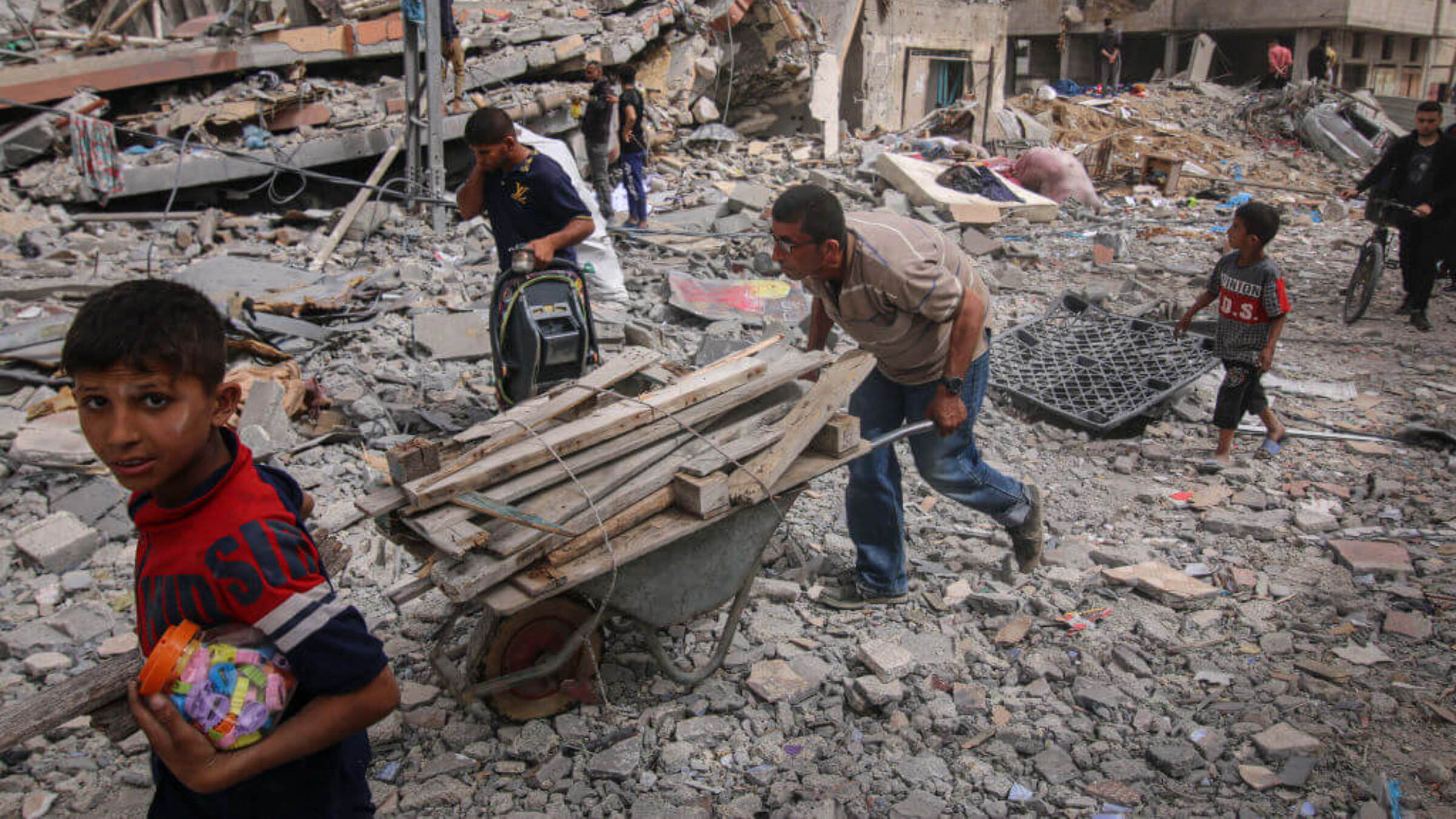 Palestinians recover items from rubble in Nuseirat camp, central Gaza Strip, on Thursday, April 18, 2024.