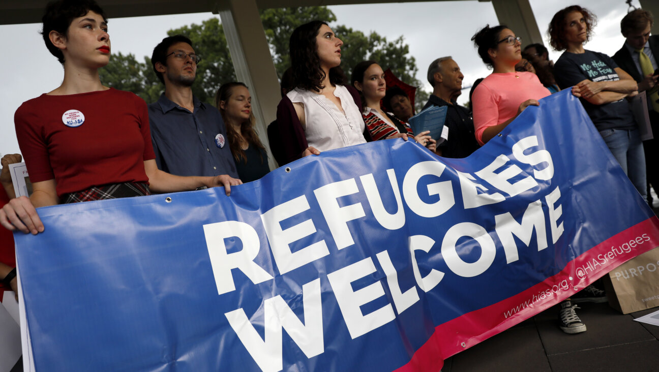 Activists hold a banner during a demonstration organized by HIAS, founded as the Hebrew Immigrant Aid Society, in 2017. The organization laid off 12% of its American workforce this week after discovering financial mismanagement.