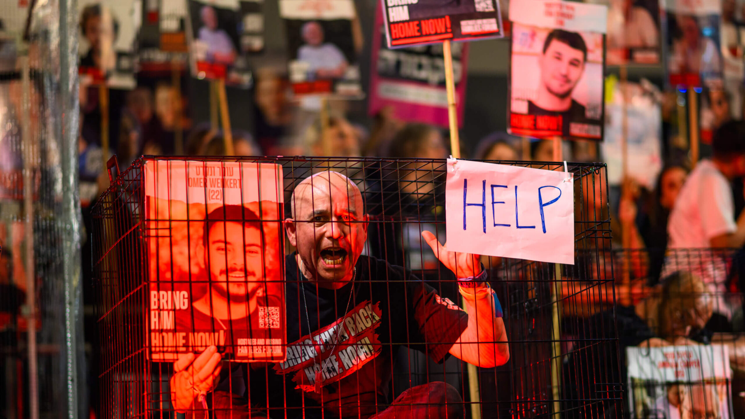 A protestor sitting in a cage screams during the 'Bring them home now' rally, March 30 in Tel Aviv, Israel. According to the families of hostages forum, this would be the last week a rally is held at Hostages Square, citing that the government is not serious about negotiations, and instead, will be joining anti-government protests.