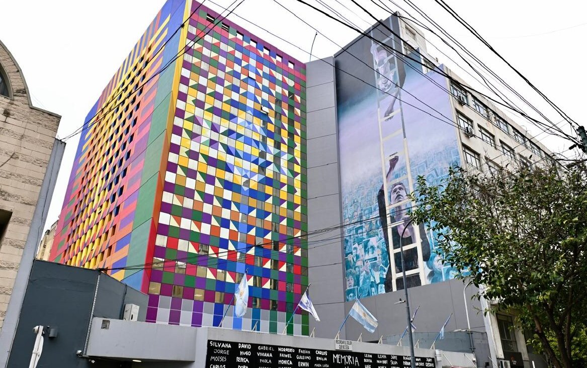 The colorful new facade of Buenos Aires’ AMIA Jewish center abuts a mural painted to memorialize the 1994 bombing that killed 85 people there. (Juan Melamed)