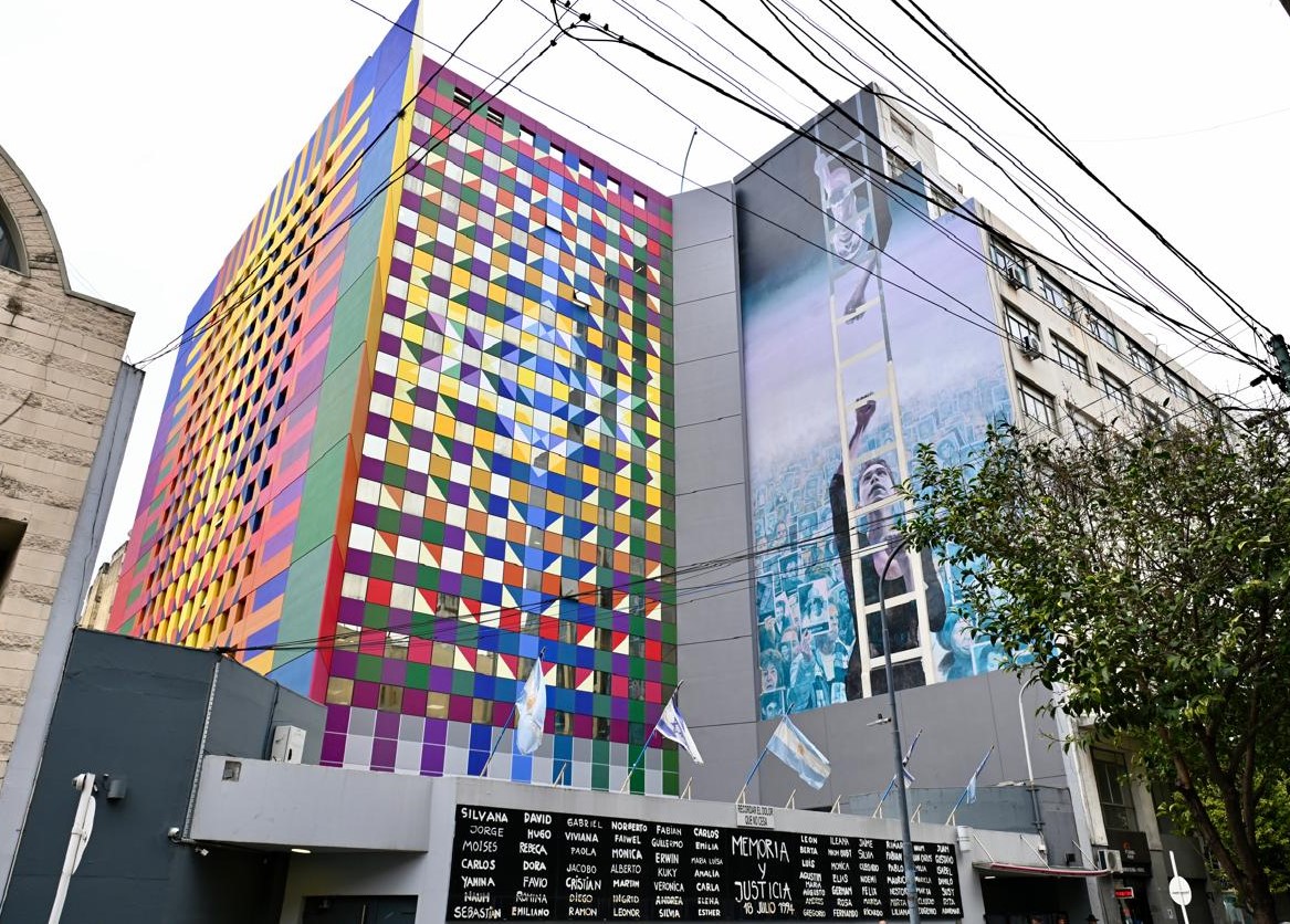 The colorful new facade of Buenos Aires’ AMIA Jewish center abuts a mural painted to memorialize the 1994 bombing that killed 85 people there. (Juan Melamed)