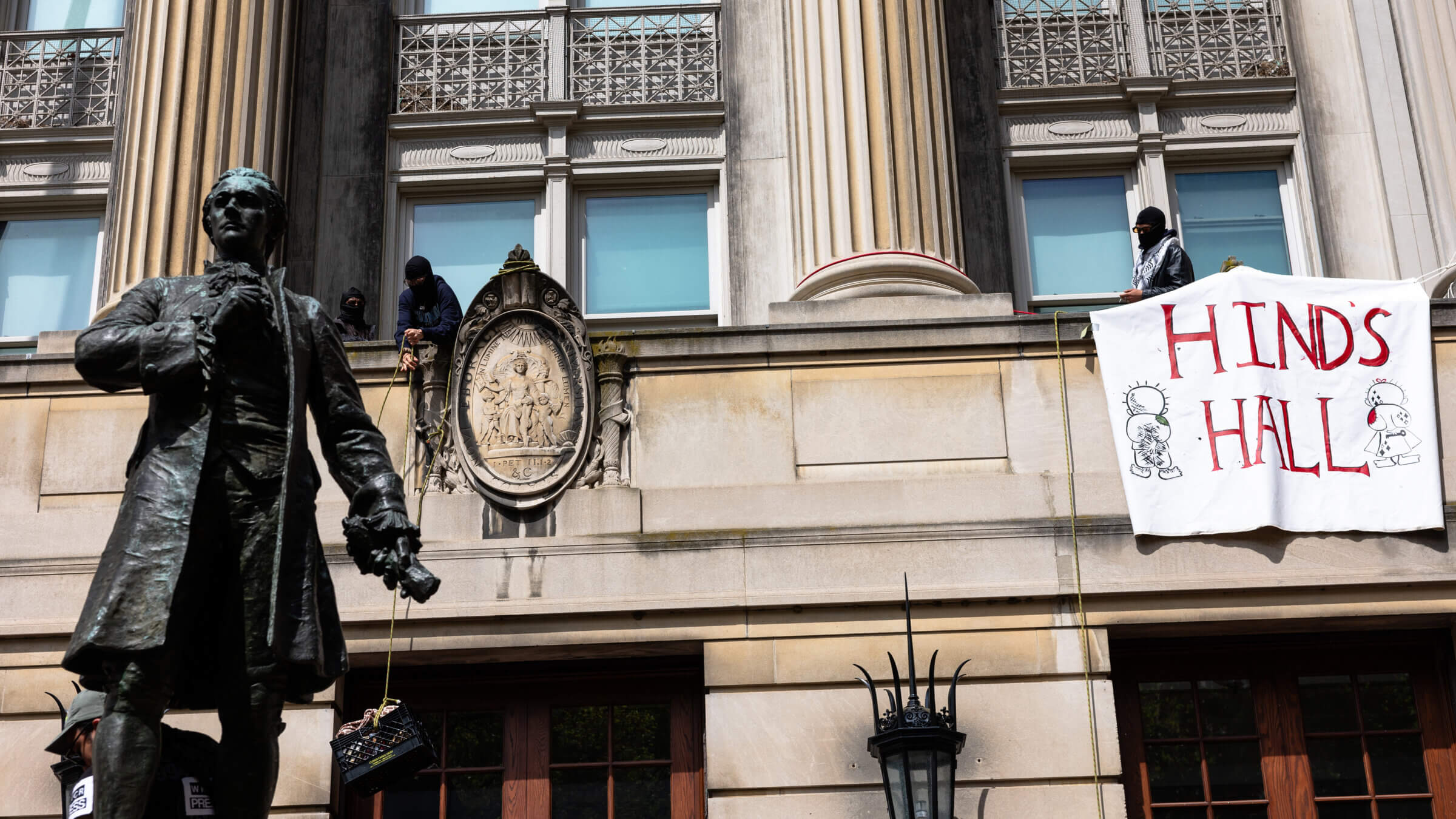 A pro-Palestinian protestor lifts a milk crate with supplies while occupying Hamilton Hall at Columbia University in New York, US, on Tuesday, April 30, 2024.