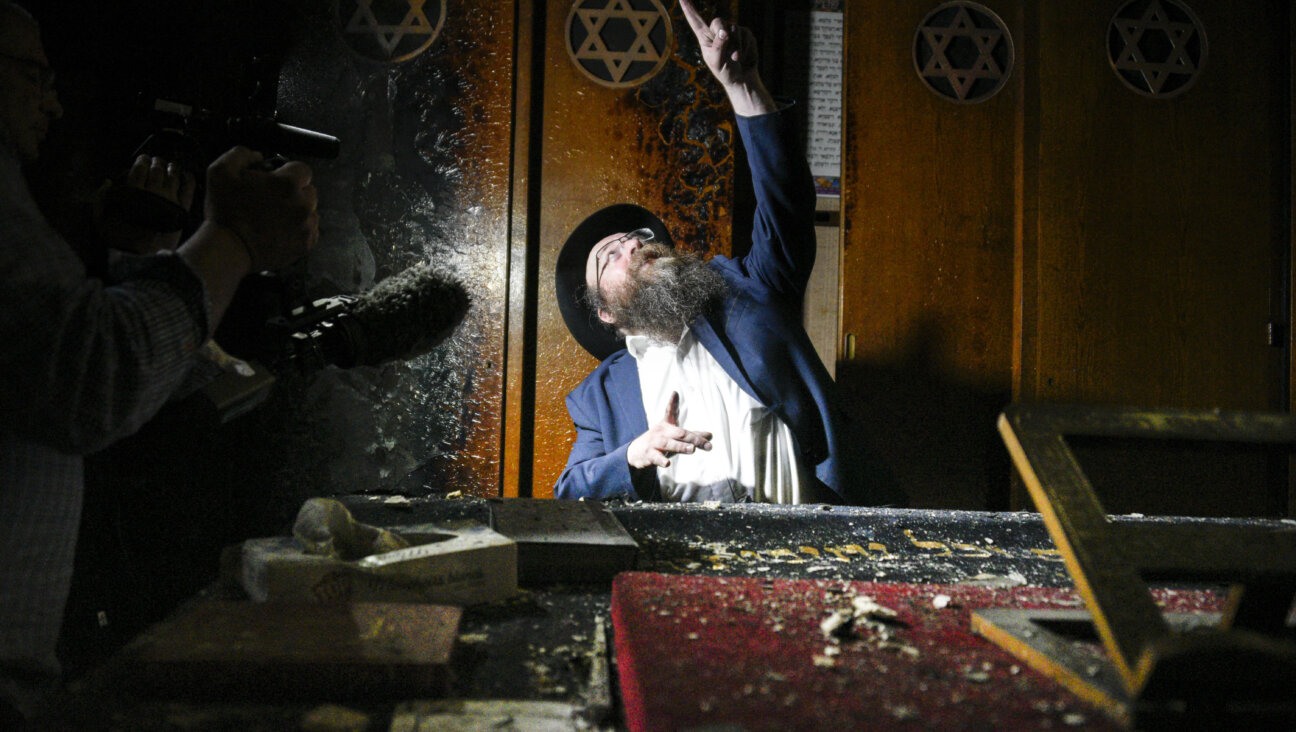 The rabbi of Rouen, Chmouel Lubecki, shows the fire damage in Rouen's main synagogue.