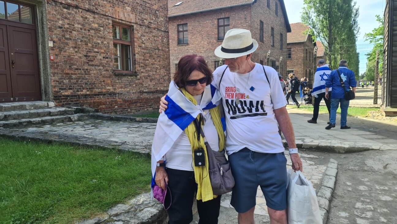 Bellha Haim, whose son Yotam was held hostage in Gaza and killed there by the Israeli army, and Tom Hand, whose 9-year-old daughter was released from Hamas captivity in November, embrace during the International March of the Living at Auschwitz, May 6, 2024. (Deborah Danan)